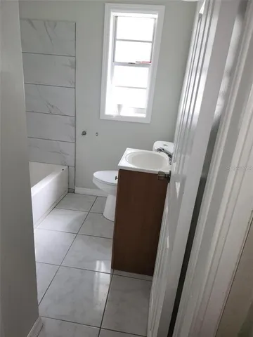 a backyard of a house with table and sofas