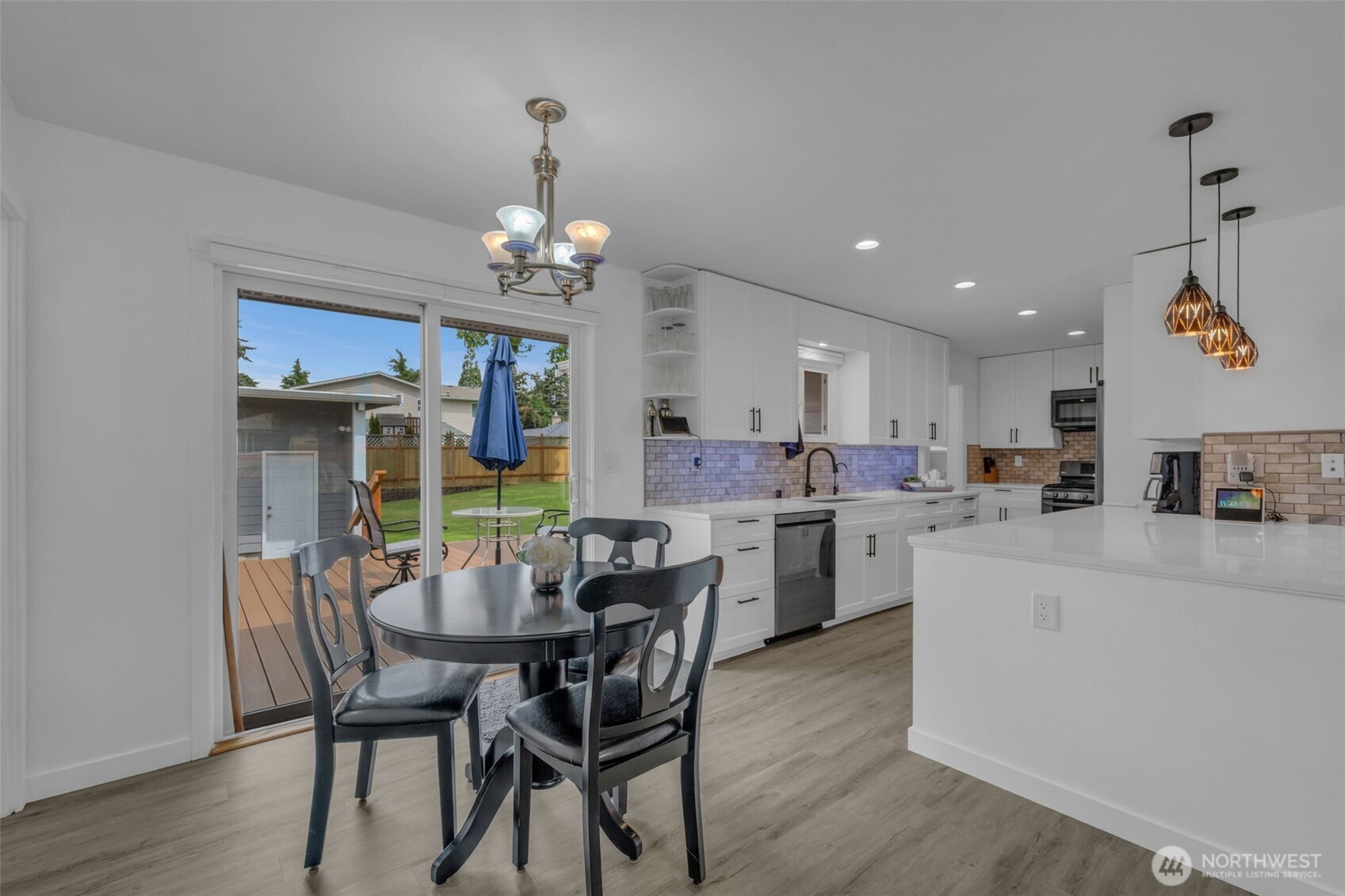 9015 218th Street Southwest Edmonds, WA 98026 - Photo 13 of 39 a kitchen with stainless steel appliances kitchen island granite countertop a dining table chairs and white cabinets