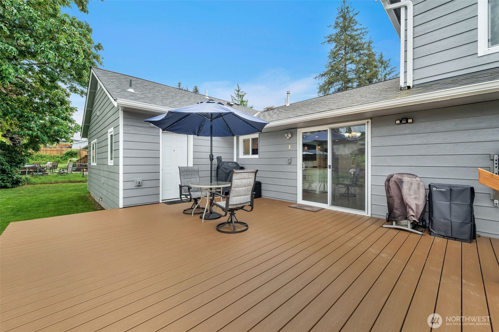 9015 218th Street Southwest Edmonds, WA 98026 - Photo 32 of 39 a view of a deck with table and chairs under an umbrella with a barbeque