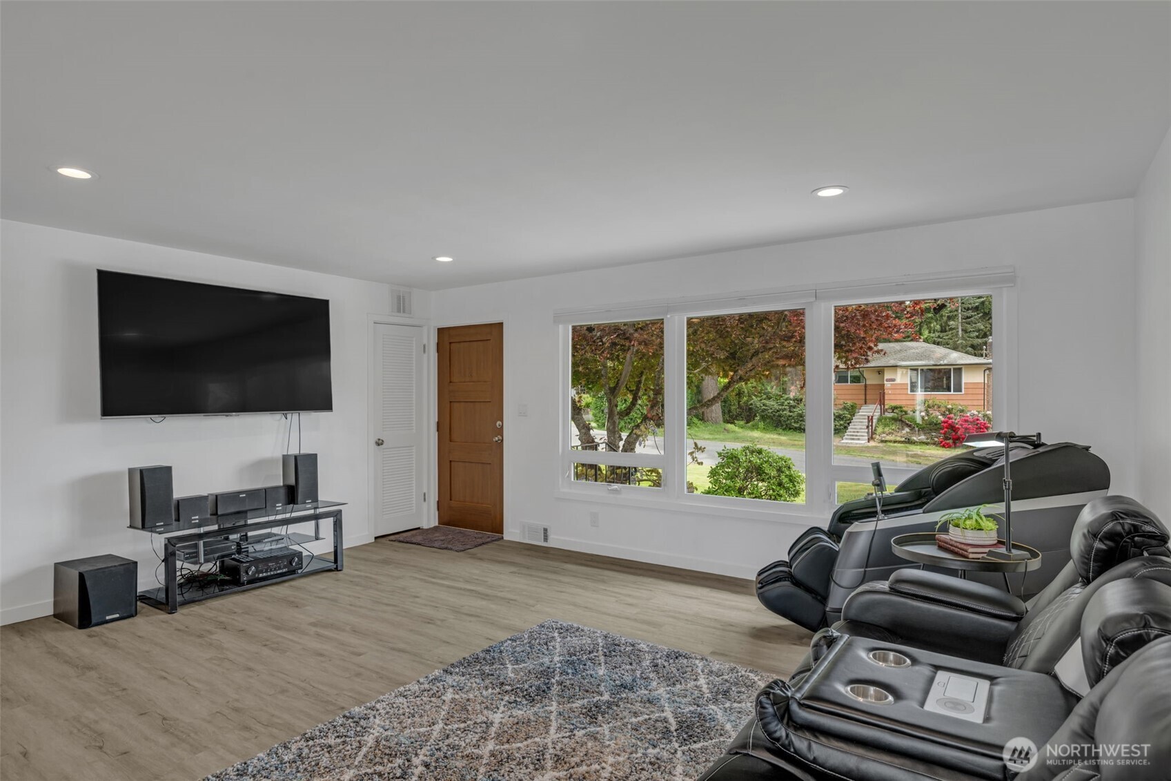 9015 218th Street Southwest Edmonds, WA 98026 - Photo 9 of 39 a living room with furniture a flat screen tv and a floor to ceiling window
