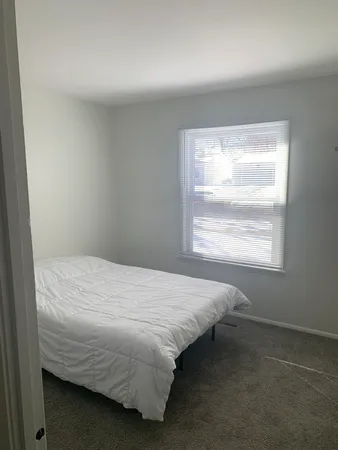 a bed sitting in a bedroom next to a window