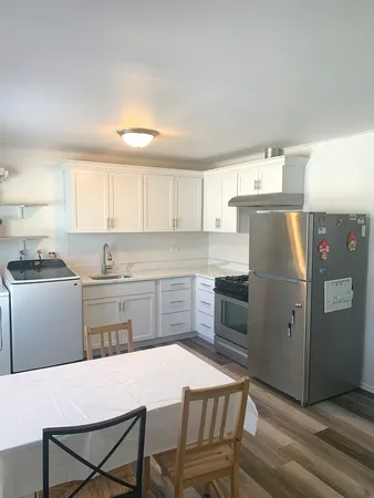 a kitchen with a refrigerator a stove a sink and cabinets