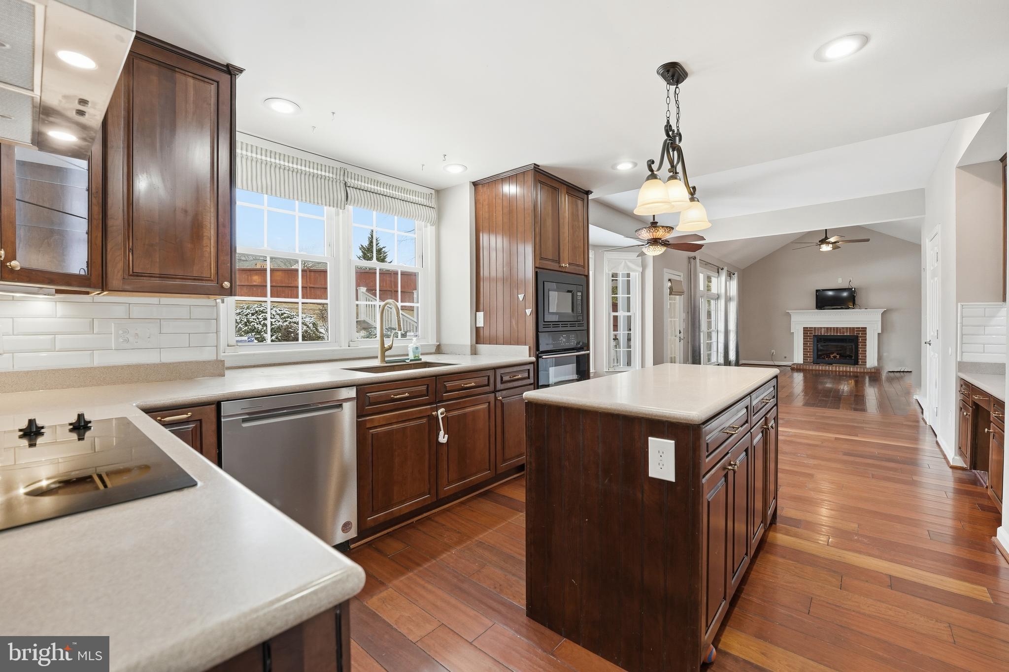 3582 Lions Field Road Triangle, VA 22172 - Photo 18 of 66 a kitchen with stainless steel appliances granite countertop wooden cabinets a sink dishwasher a stove and a refrigerator with wooden floor
