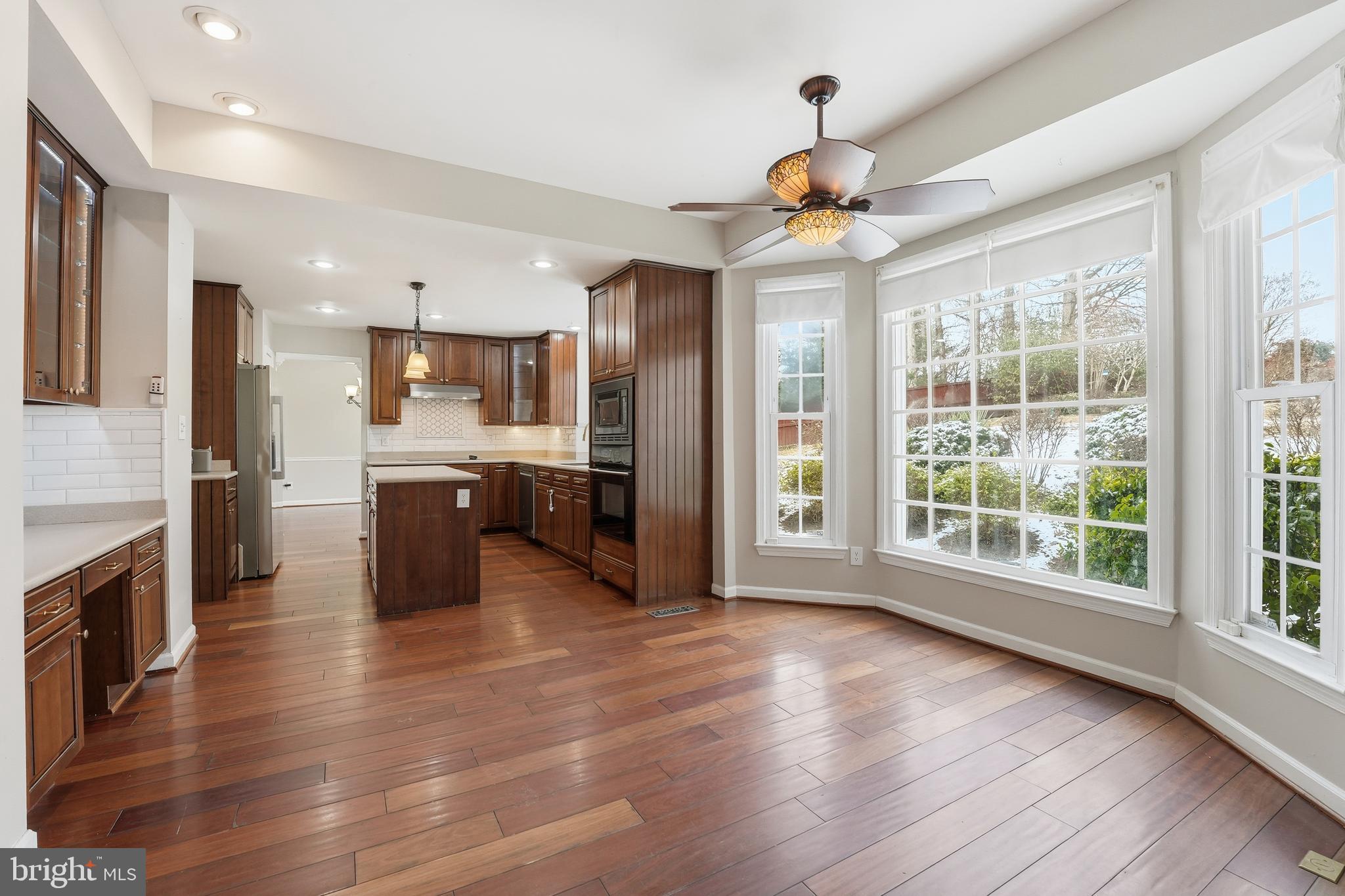 3582 Lions Field Road Triangle, VA 22172 - Photo 23 of 66 a large kitchen with stainless steel appliances kitchen island granite countertop a refrigerator a stove a sink dishwasher and a fireplace with wooden floor
