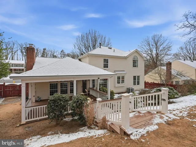 a kitchen with stainless steel appliances granite countertop wooden cabinets a sink dishwasher a stove and a refrigerator with wooden floor