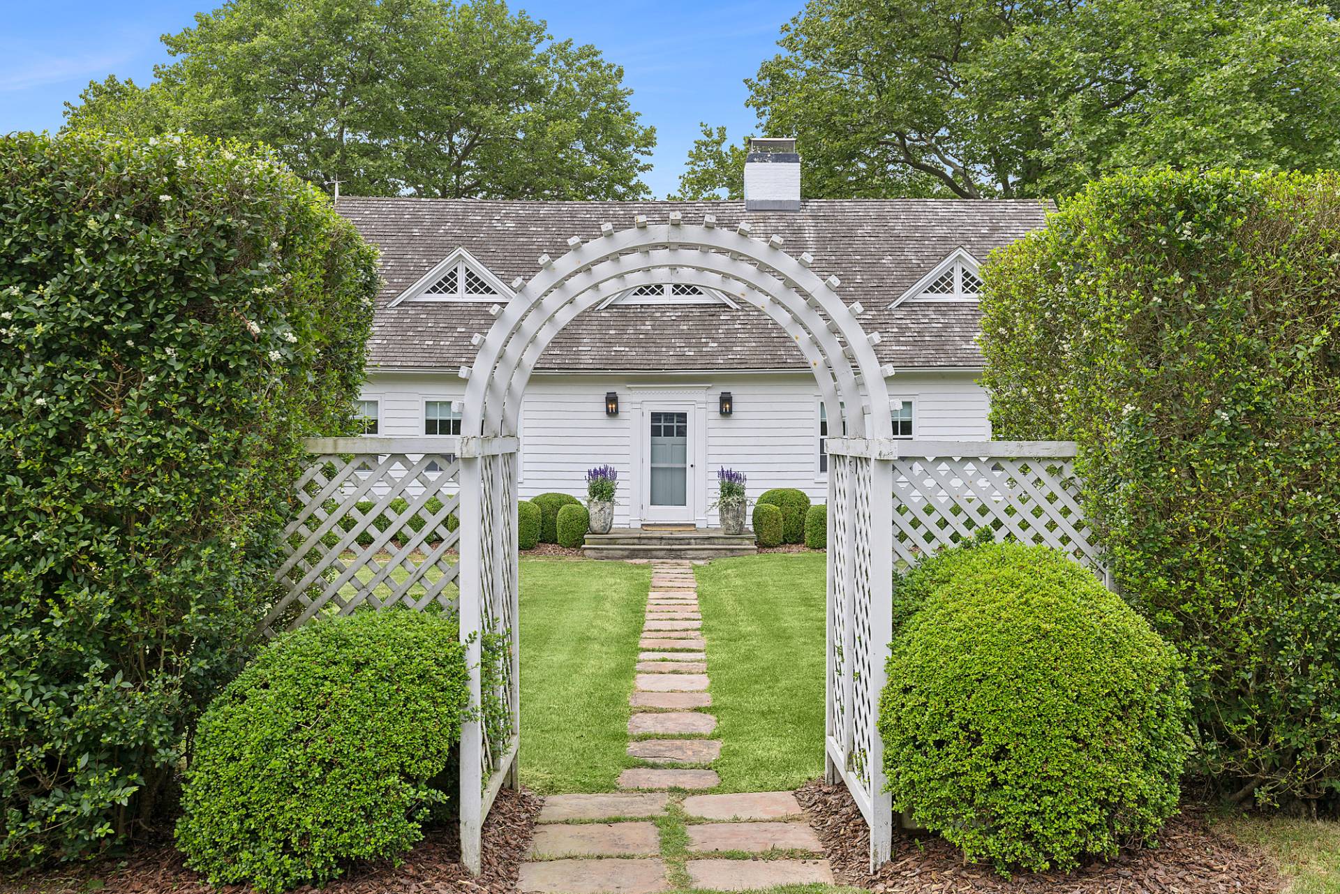 93 Egypt Lane East Hampton, NY 11937 - Photo 3 of 50 a front view of a house with a garden