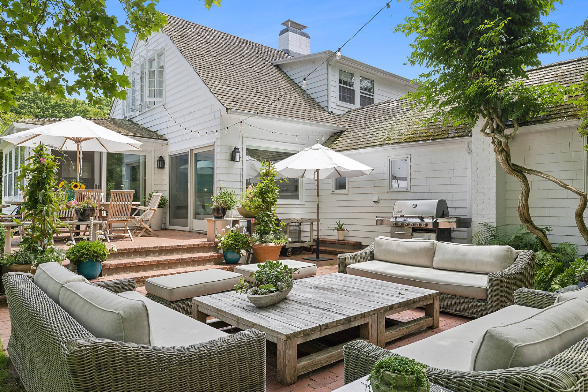 93 Egypt Lane East Hampton, NY 11937 - Photo 10 of 50 a view of a patio with couches table and chairs under an umbrella