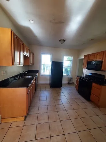 a kitchen with stainless steel appliances granite countertop a refrigerator a stove and a sink