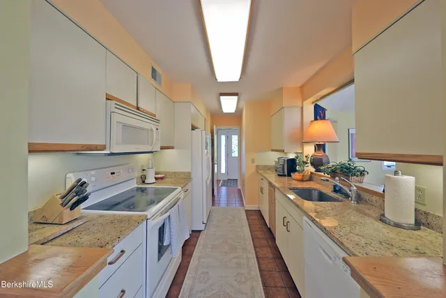 a large kitchen with stainless steel appliances granite countertop a sink and a stove