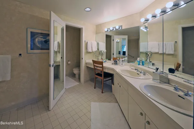 a large bathroom with a double vanity sink mirror and shower