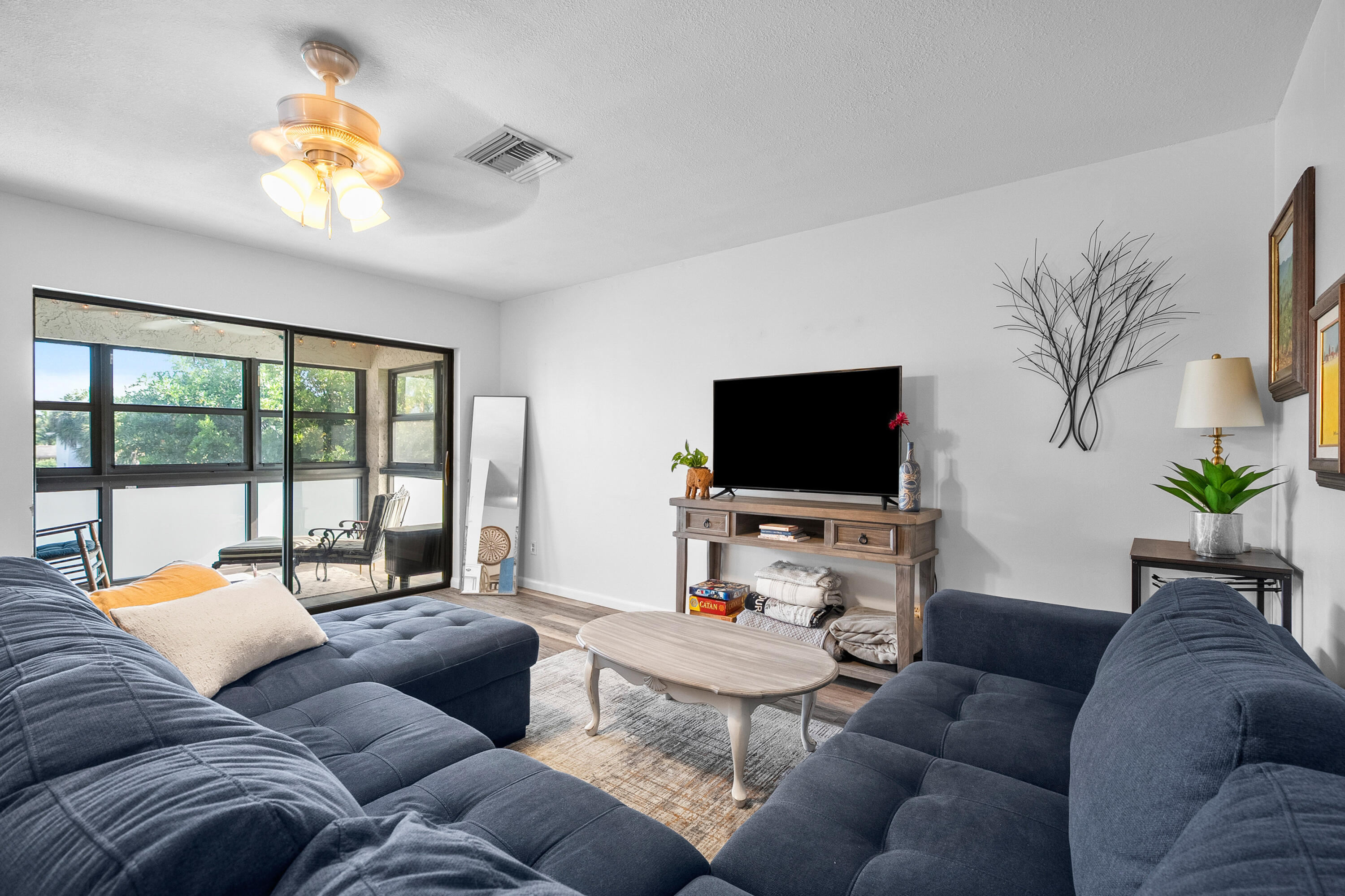 1250 Southeast Parkview Place, Unit C10 Stuart, FL 34994 - Photo 2 of 19 a living room with furniture and a flat screen tv
