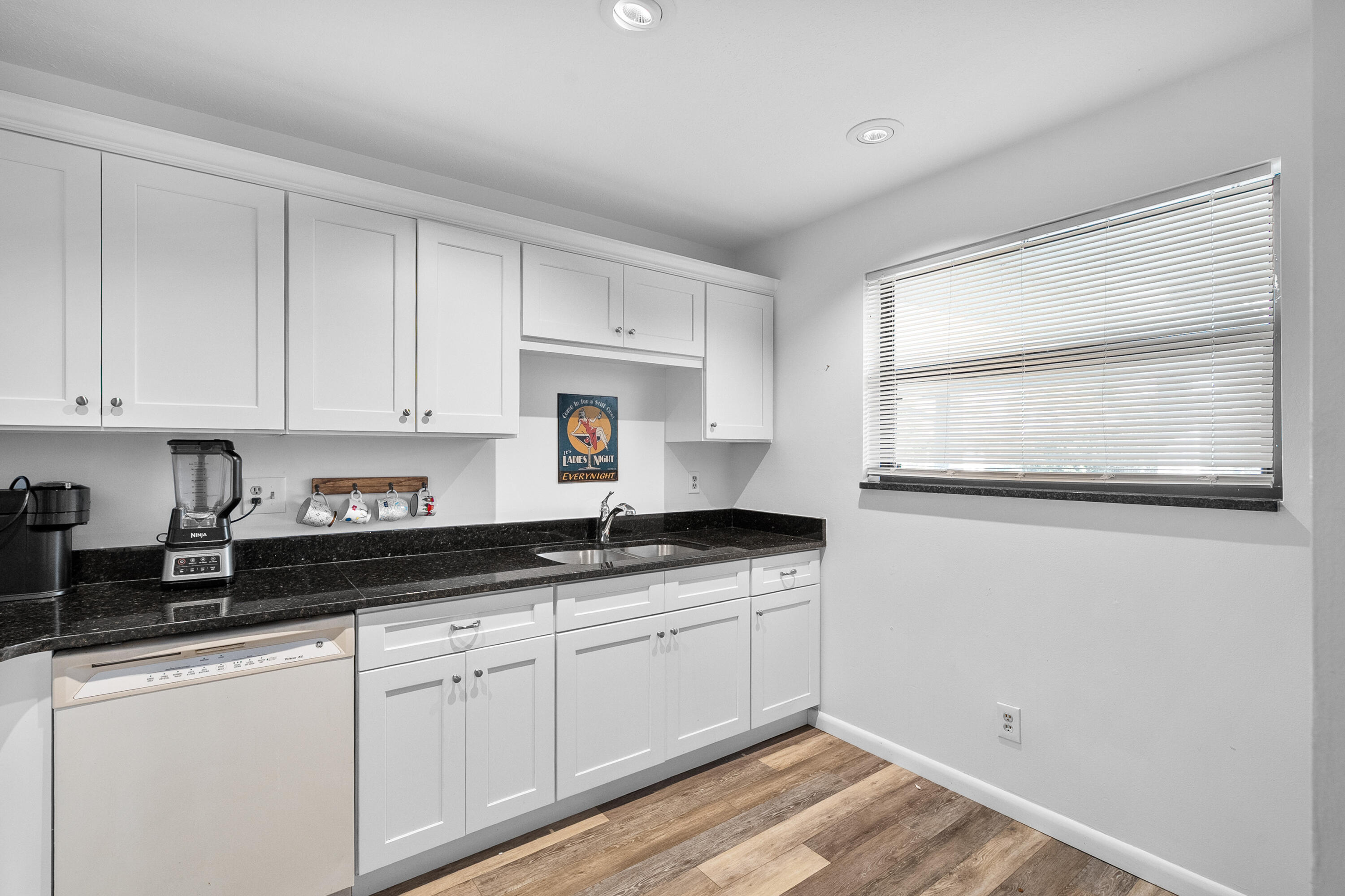 1250 Southeast Parkview Place, Unit C10 Stuart, FL 34994 - Photo 6 of 19 a kitchen with granite countertop white cabinets and white appliances