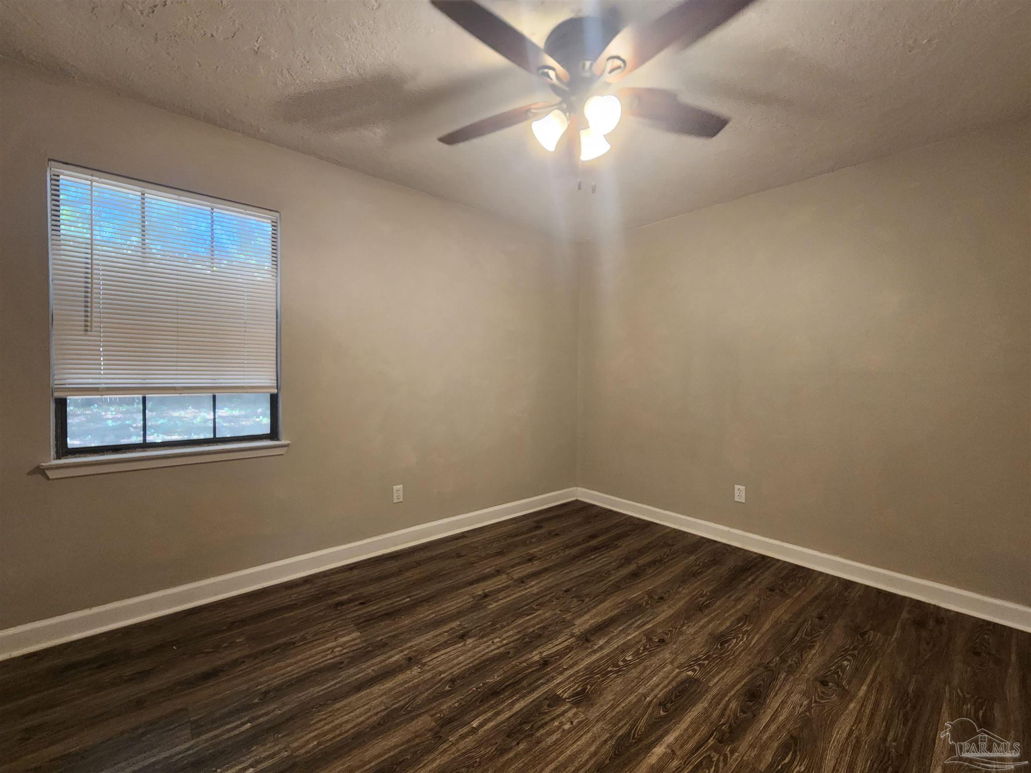 4839 Lynn Drive Pace, FL 32571 - Photo 15 of 24 a view of an empty room with wooden floor and a window