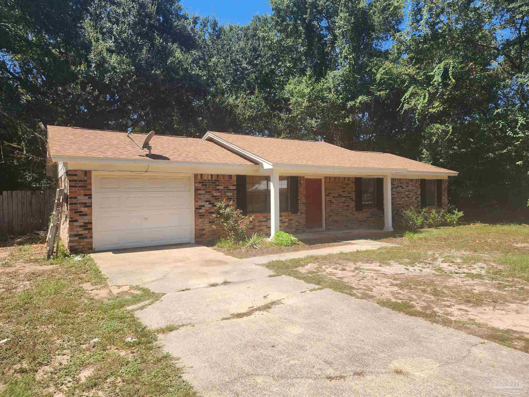 4839 Lynn Drive Pace, FL 32571 - Photo 3 of 24 a front view of a house with a yard and garage