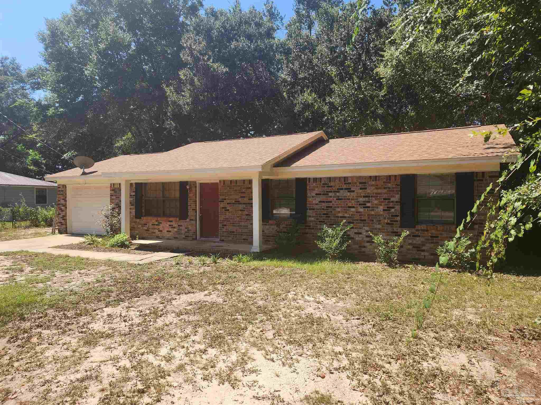 4839 Lynn Drive Pace, FL 32571 - Photo 4 of 24 a front view of a house with a yard and garage