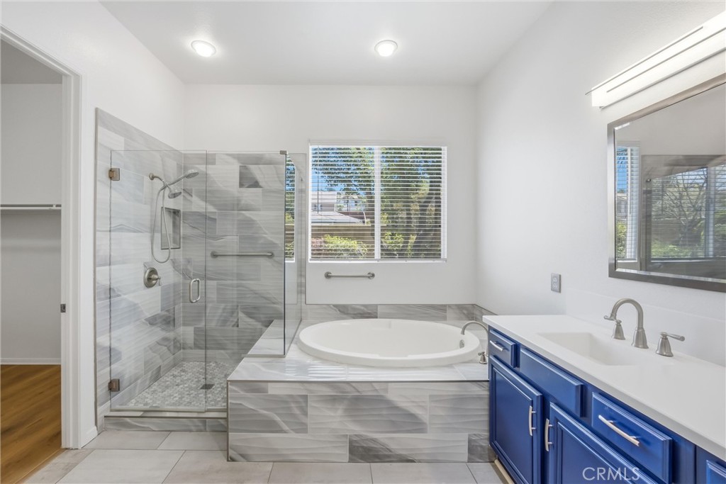 8710 Windmill Place Riverside, CA 92508 - Photo 34 of 66 a bathroom with a granite countertop sink a mirror and a bathtub