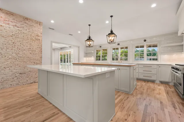 a kitchen with granite countertop a sink cabinets and wooden floor