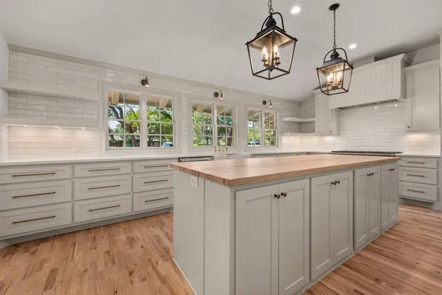 a kitchen with white cabinets and chandelier