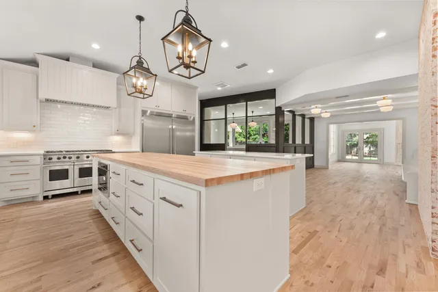 a large kitchen with stainless steel appliances a large counter space a sink and cabinets