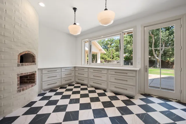 a room with a black white checkered floor and a fireplace