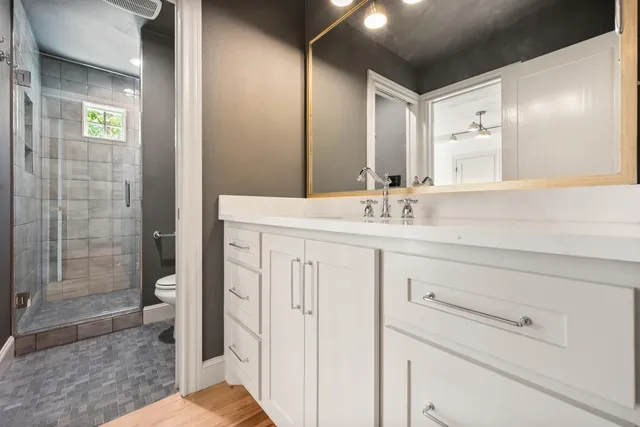 a bathroom with a sink a toilet and shower