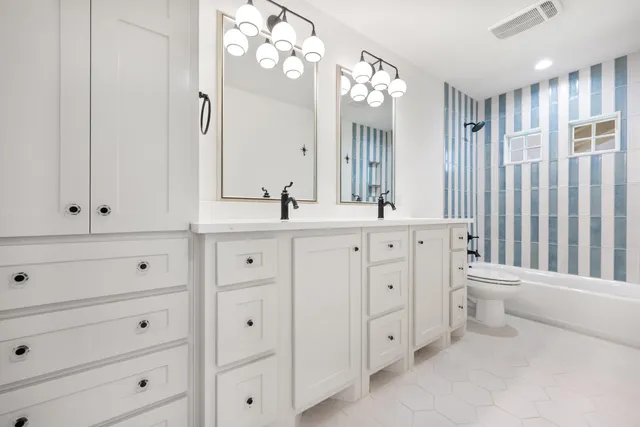 a bathroom with a double vanity sink mirror and