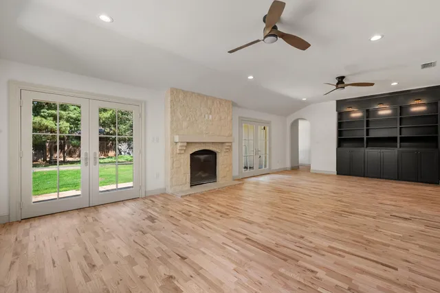 a view of an empty room with a fireplace and a window