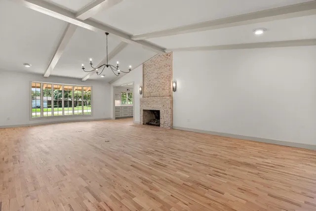 a view of an empty room with a fireplace and a window