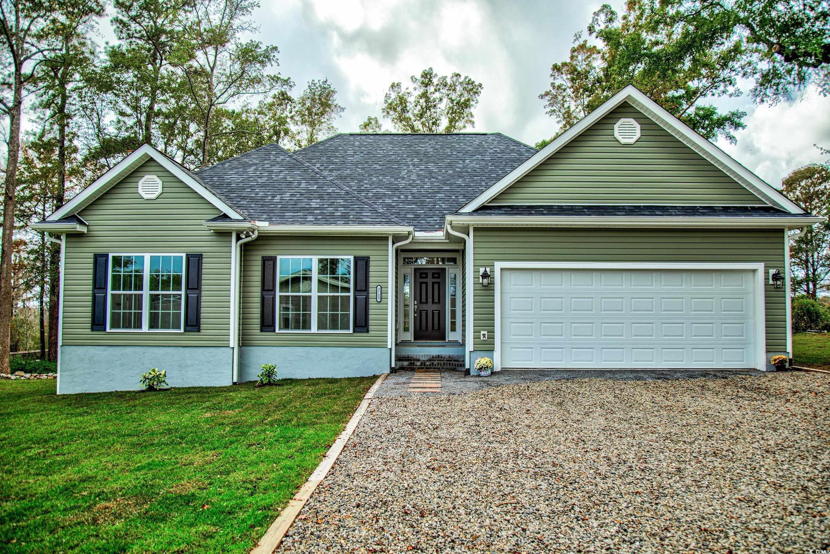 Ranch-style house featuring a front yard and a garage
