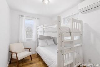 80 Louse Point Road East Hampton, NY 11937 - Photo 13 of 19 a bedroom with a bed and a chair