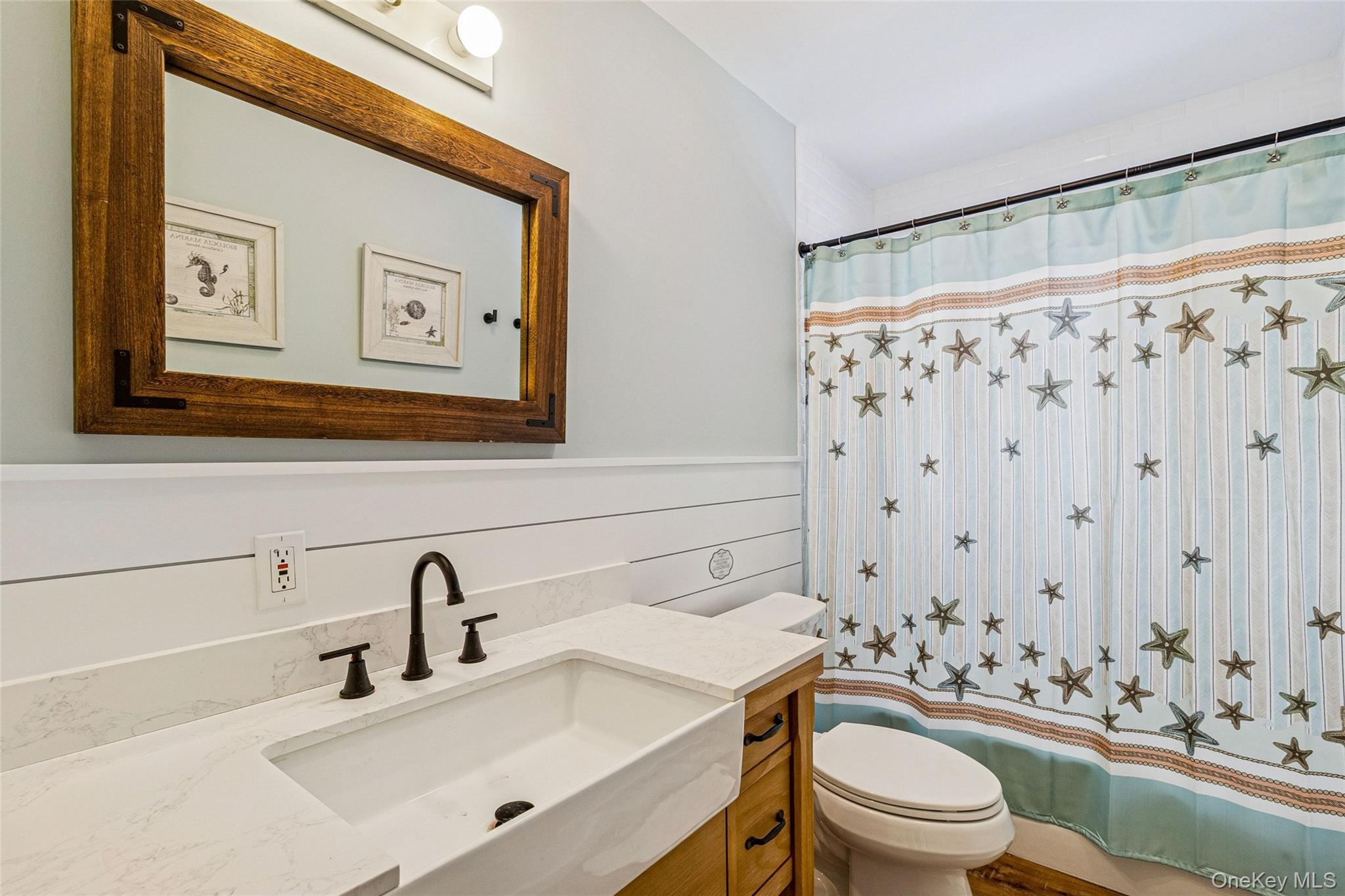 80 Louse Point Road East Hampton, NY 11937 - Photo 15 of 19 a bathroom with a sink a toilet and shower curtain