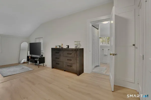 a view of a bedroom with cabinet flat tv screen and windows