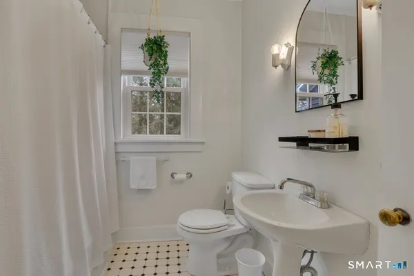 a bathroom with a sink a toilet and mirror