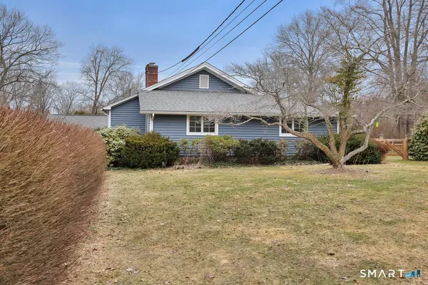 a front view of house with yard and trees around