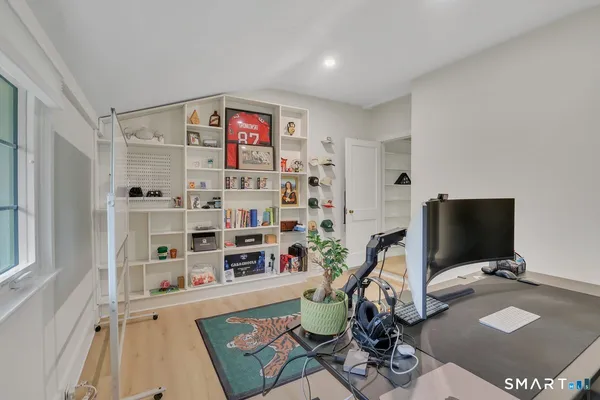 a work room with furniture a flat screen tv and a bookshelf