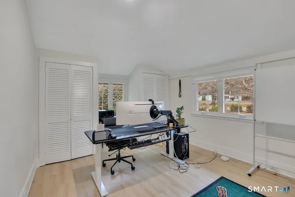 a view of a workspace with furniture and a window