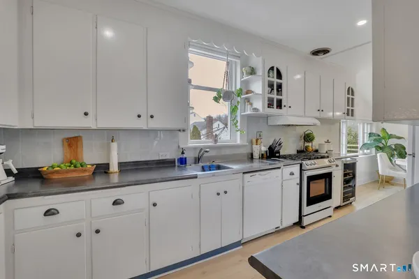 a kitchen with granite countertop white cabinets and white appliances