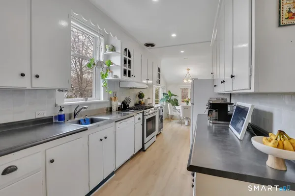 a kitchen with stainless steel appliances granite countertop a sink a stove top oven a counter space and cabinets