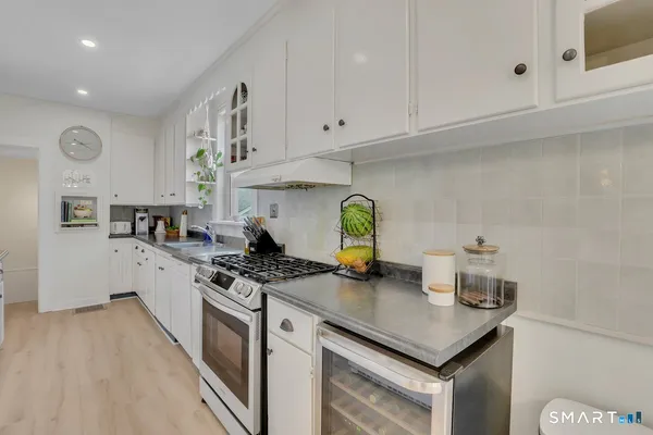 a kitchen with stainless steel appliances granite countertop a sink stove and cabinets