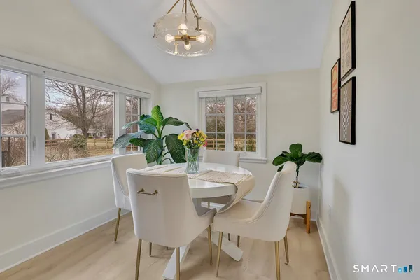 a view of a dining room with furniture a livingroom and chandelier