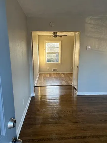 a view of empty room with wooden floor