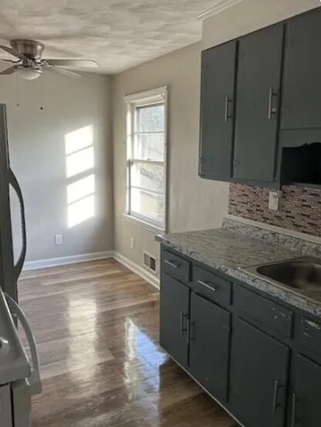 a view of a kitchen with a sink hardwood floor and a fireplace