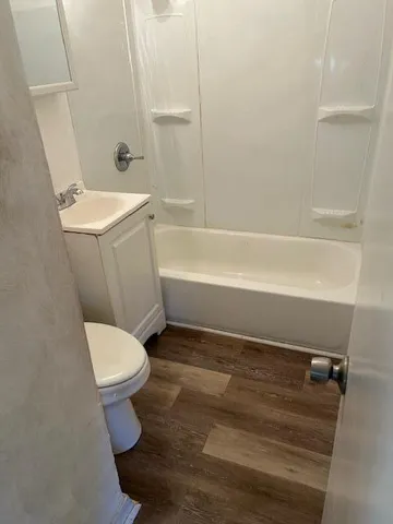 a white toilet sitting next to a bath tub