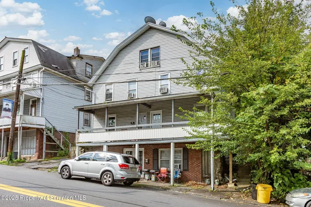 a front view of a building with parked cars