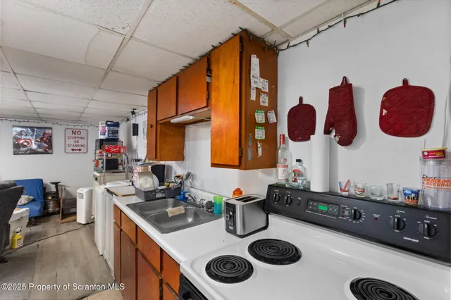 a kitchen with a sink a stove and a wooden floor