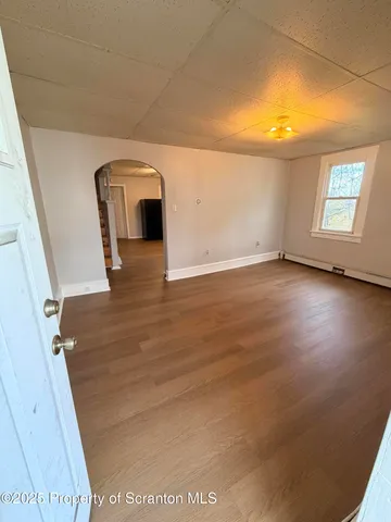 a view of a livingroom with wooden floor and a ceiling fan