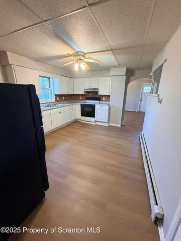 a view of a refrigerator in kitchen and a sink