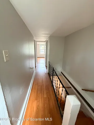 a view of a hallway with wooden floor