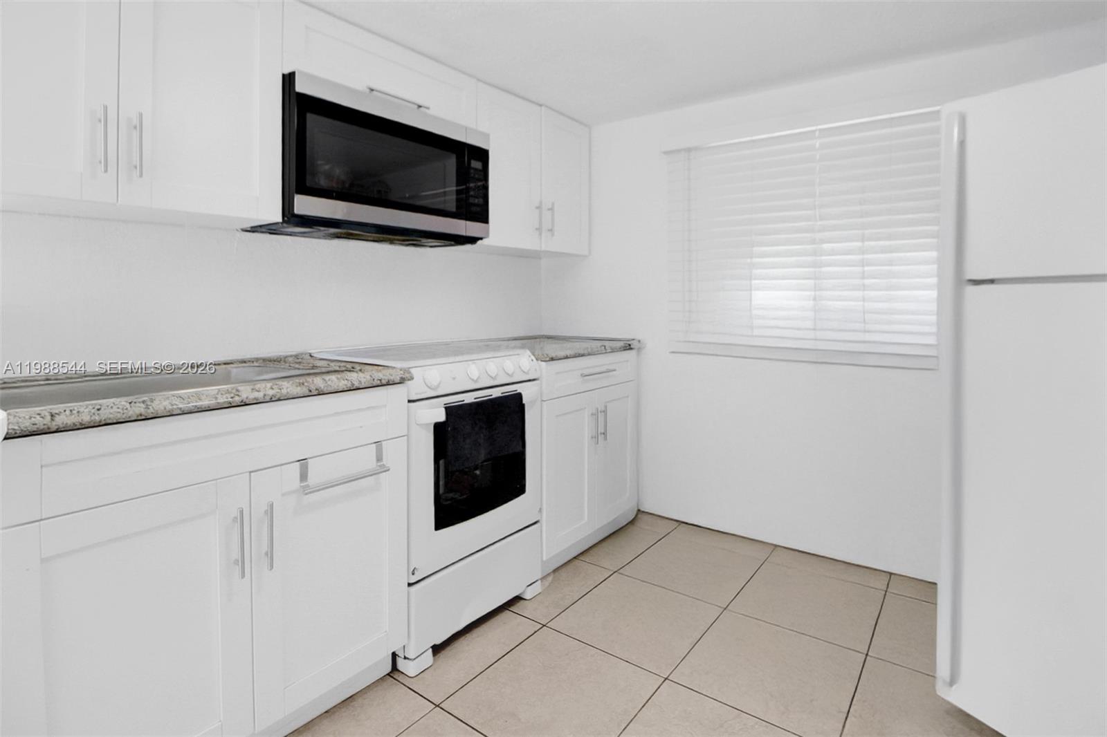 2900 Northwest 95th Street Miami, FL 33147 - Photo 6 of 48 a kitchen with white cabinets stainless steel appliances and a sink