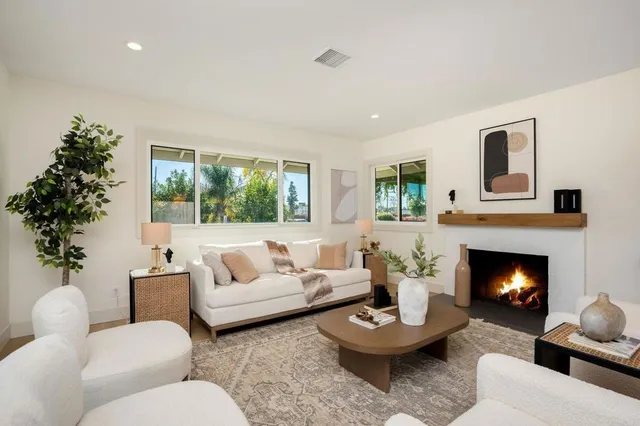 a living room with furniture a fireplace a window and a fireplace
